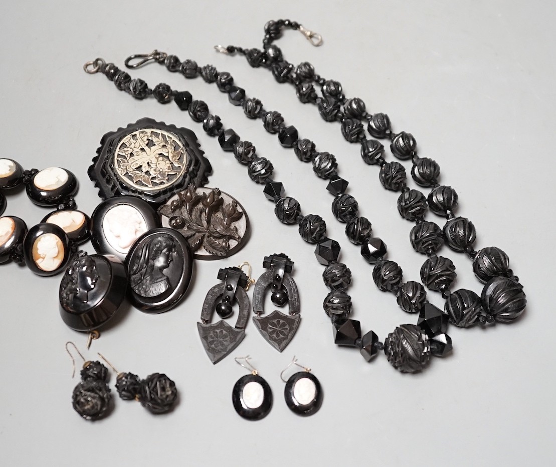 A collection of assorted jet jewellery, some with cameo, including two necklaces, five brooches, a bracelet and three pairs of earrings.